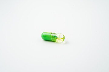 Transparent capsules with a mixture of green powder and oil, Food supplements, vitamins