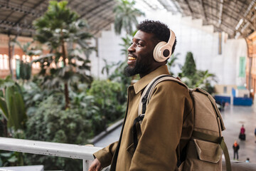 Traveler listening music with headphones in atocha station madrid