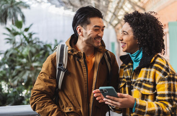 Fototapeta premium Travelers consulting their smartphone, smiling and having fun together