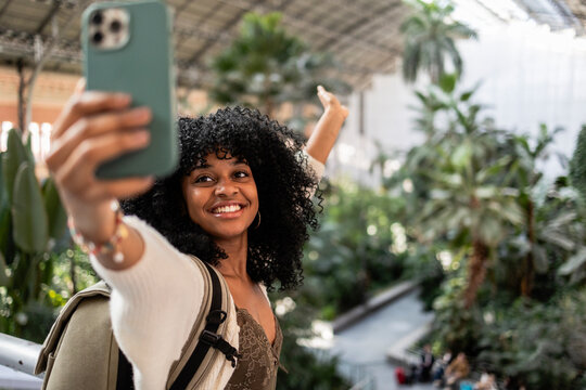 Young black woman taking selfie at atocha station in madrid