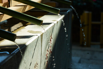 陽が差す神社の手水鉢