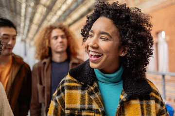 Fototapeta premium Young woman laughing with friends at the train station