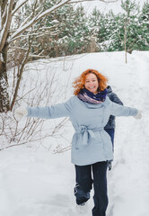 Love romantic love story. Happy couple of middle aged millennials, bright red-haired woman in winter snow park. Romantic date, kissing, hugging. Walking, having fun. Stylish blue clothes, jacket, hat