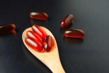 Vitamin capsules in a wooden spoon, soft gels, Fish oil capsules, omega 3, omega 9, vitamin D,...