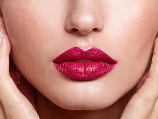 Fototapeta premium Close-up view of perfectly applied bold lipstick on smooth lips with soft skin tone