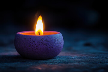 Purple candle burning in darkness.