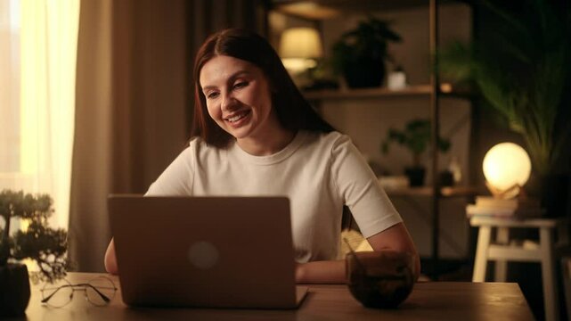 Happy Freelancer Talking at Computer Video Call. Smart girl student studying remotely by video call. Portrait of Smiling Woman Listening Online Course by Laptop Conference