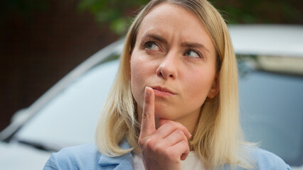 Confused puzzled Caucasian female owner driver woman thinking idea car problem car breakdown wonder...