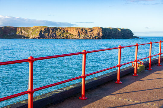 Shiny new red railings on West Pier in the harbour at Eyemouth, Berwickshire, Scottish Borders, Scotland UK