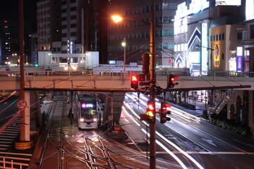 Fototapeta premium 夜の長崎の街並みの中停車する路面電車(長崎電気軌道5000形)_2023/1/15撮影