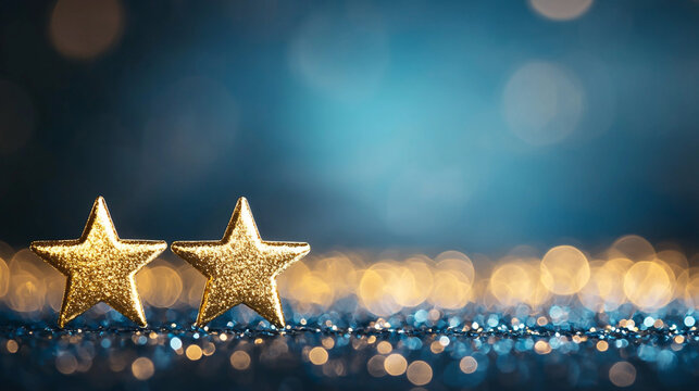 Two golden stars on a sparkling surface with blue bokeh background.