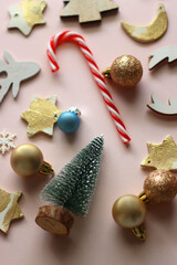 Various cute Christmas ornaments on pale pink background. Selective focus.