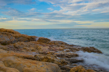 Aerial panorama of Thailand's verdant, lush tropical island, National Park Island, with blue and aquamarine the sea, and clouds shining by sunlight in the background.	