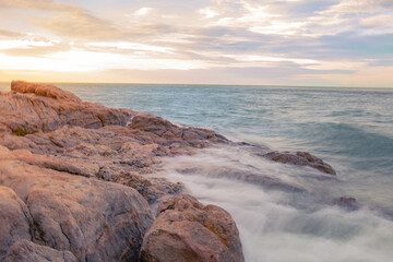 Aerial panorama of Thailand's verdant, lush tropical island, National Park Island, with blue and aquamarine the sea, and clouds shining by sunlight in the background.	