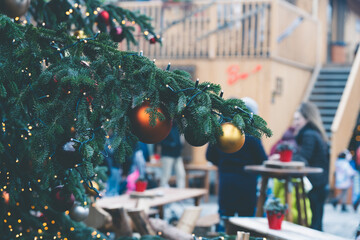 Christmas ornaments on a tree, with defocused Christmas market at the opera house - Sechselautenplatz square-Bellevue in Zurich