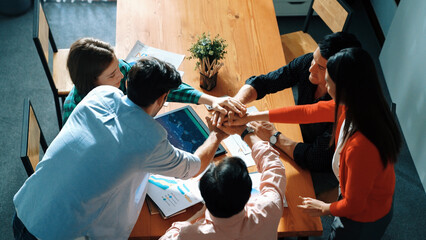Top view of happy creative team putting hands together while drawing mind map. Group of diverse people working together brainstorming marketing idea and sharing plan by using sticky notes. Convocation