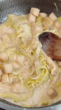 Saint-Jacques au poireaux, en cuisson, dans une po&ecirc;le	
