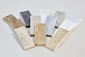 Porcelain stoneware artificial stone square samples as kitchen countertop examples of future kitchen fasade exterior. Samples slabs of natural granite marble quartz for stone countertops close up.