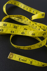 Tailor's tape measure on black background