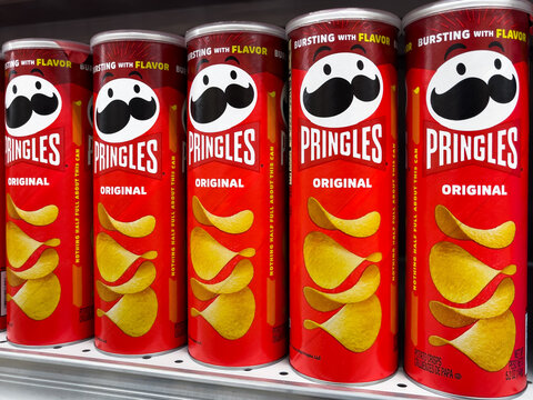 ATLANTA, GEORGIA - DECEMBER 16, 2024 : Pringles potato chip tubes on display shelf in an American grocery store supermarket.