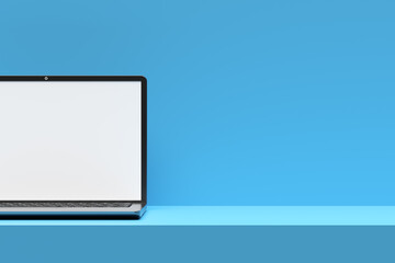 Modern laptop showing blank screen on blue desk and background