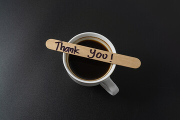 A cup of coffee with a word Thank You on black background