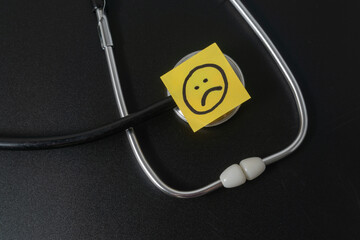 Medical concept with a bad emoji on black background