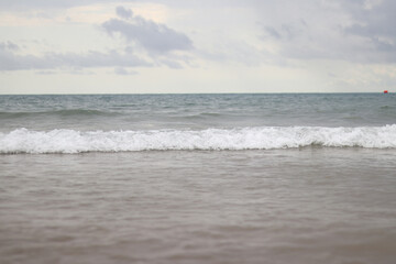 Sea view with small waves in cloudy weather. Balearic Sea, Salou, Spain. View of the waves on the sea from a lower angle. Landscape with sea and clouds
