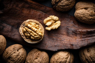 Half of cracked walnut with kernels on old wooden plank close up. Food photography