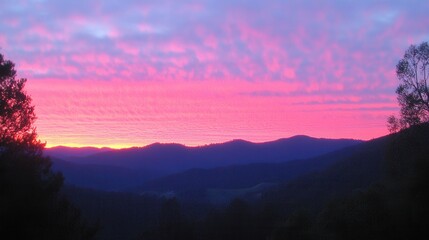 Fototapeta premium Vibrant Sunrise Over Mountain Range with Colorful Sky and Cloud Patterns