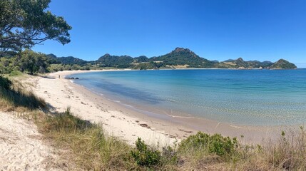 Serene Coastal Landscape with Clear Blue Water and Sandy Beach at Daytime