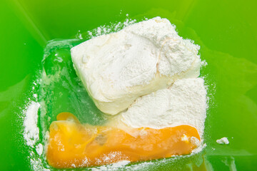Ingredients for the dough in a green bowl. Flour, butter, egg and cottage cheese