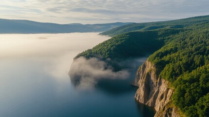 Serene Aerial View of Misty Cliffs and Lush Green Forest by Calm Water