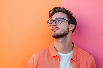 Obraz premium Thoughtful Young Man in Stylish Glasses Against a Vibrant Colorful Background