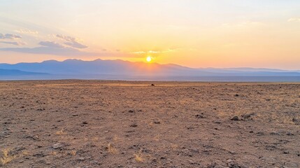 Serene Sunset Over Expansive Desert Landscape with Mountain Silhouettes