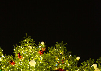 Christmas tree decorated with garlands and Christmas balls in red and white against the background...