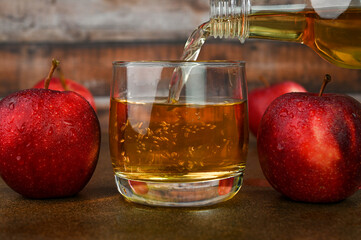 Pouring apple cider vinegar in a glass cup.