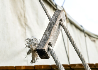 Using a wooden block with holes as a tent guy line anchor