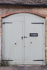 Traditional garage door with no parking sign in old brick wall.