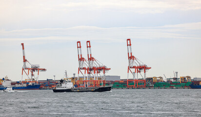 Fototapeta premium Container port at Osaka Japan, Industrial port for cargo container ship. Cargo transportation and activity at modern shipping container terminal.