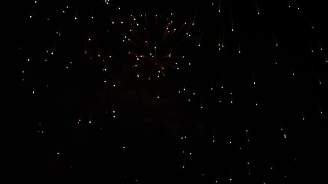 Golden silver blue sparks scattering fireworks on the black night sky. General plan