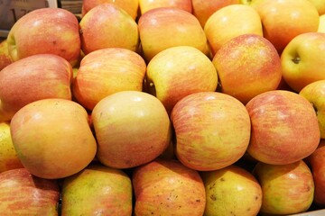 Fresh apples of different varieties. Red, green and yellow fruits are neatly laid out on the store counter, creating a bright and appetizing composition.