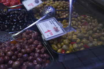 Olives on a market stall. Food photography. Mix of green and black varieties with a glossy, appetizing shine. Olives laid out in a rustic setting, healthy eating