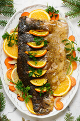 Traditional whole Polish Christmas carp with oranges and vegetables..top veiw