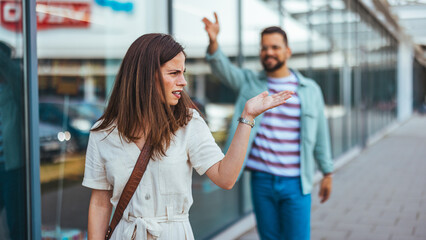 Woman Reacting Angrily to a Man Waving Outdoors Near a Storefront