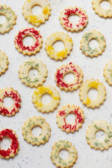 Christmas cookies lemon rings with colorful sprinkles on a Christmas rustic background