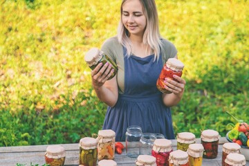 A woman preserves vegetables in jars. Selective focus