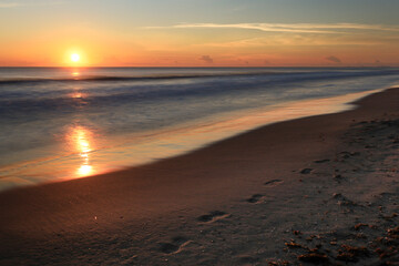 Footprints on the sand on the beach at sunrise in Arenales del Sol, Alicante