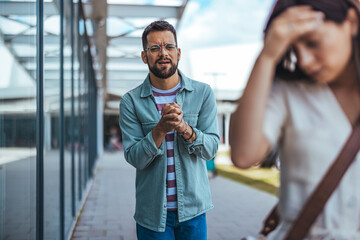 Man Expressing Regret Towards a Distressed Woman in an Outdoor Setting