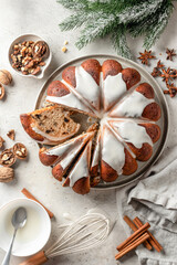 Christmas gingerbread cake sliced on white table with fir branches and spices. Christmas festive dessert, homemade holiday baking recipe. Top view